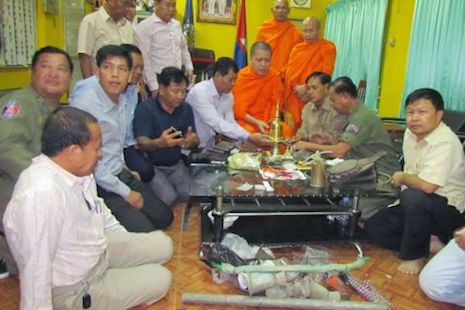 <p>Cambodian authorities and monks gather around a golden urn from Oudong Mountain and other seized items at a police station in Kandal province in February (Photo supplied)</p>
