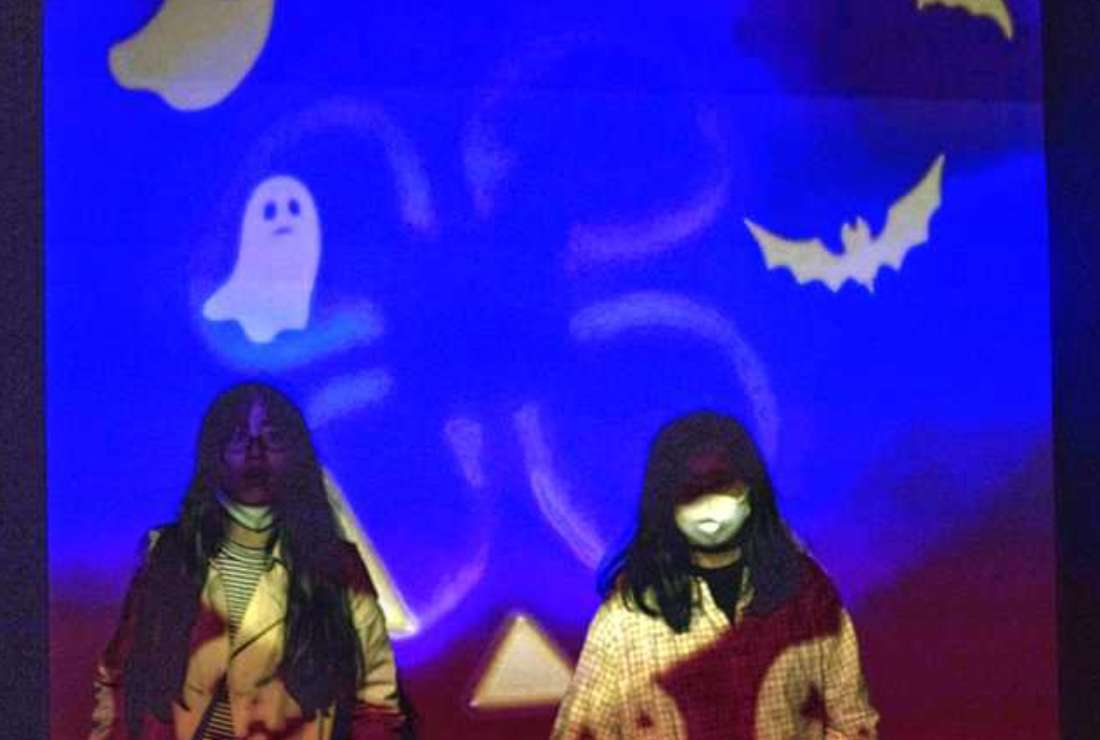 Visitors walk past a projection displaying Halloween ghosts and bats on a wall during a special Halloween exhibition at Sumida Aquarium in Tokyo on Oct. 29, 2020