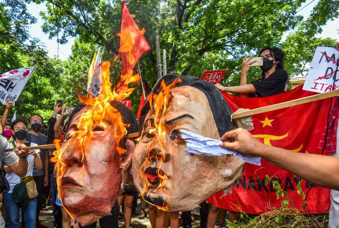 Protesters burn effigies of incoming president Ferdinand Marcos Jr. and Vice President Sara Duterte during a rally at the Commission on Human Rights in Quezon City, suburban Manila, on May 25
