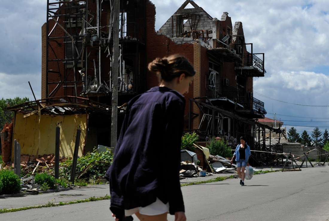 Women walk past a destroyed building in the town of Makariv in Ukraine's Kyiv region on June 15 as the Russian-Ukraine war enters its 112th day