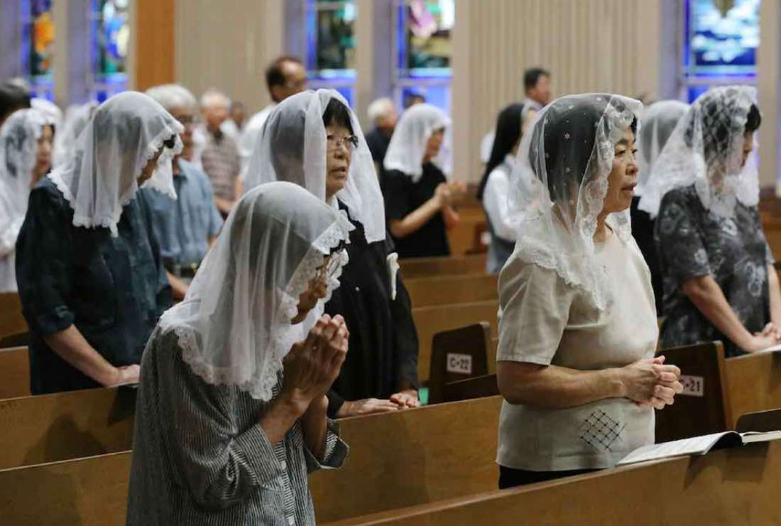 Christians pray for victims during a mass to mark the anniversary of the atomic bombing at the Urakami Cathedral in Nagasaki, western Japan, on August 9, 2017