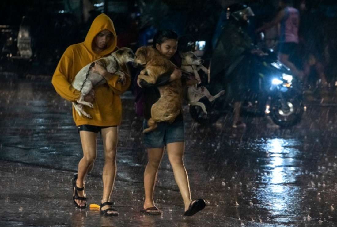 Residents carrying their family pets to the safety of an evacuation center amid heavy rain brought by Super Typhoon Noru in Marikina city, suburban Manila, Philippines on Sept. 25
