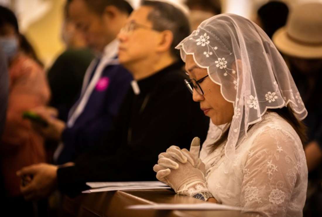 A woman prays inside St Dominic's Church before the mass to celebrate the Feast Day of Our Lady of Fatima in Macau on May 13