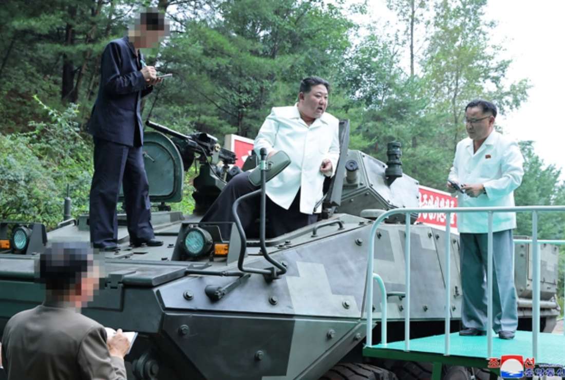 This undated photo released from North Korea's official Korean Central News Agency (KCNA) on Aug. 14 shows North Korea's leader Kim Jong-un (center) on a multi-purpose armored vehicle after a visit to an important munitions factory at an undisclosed location in North Korea