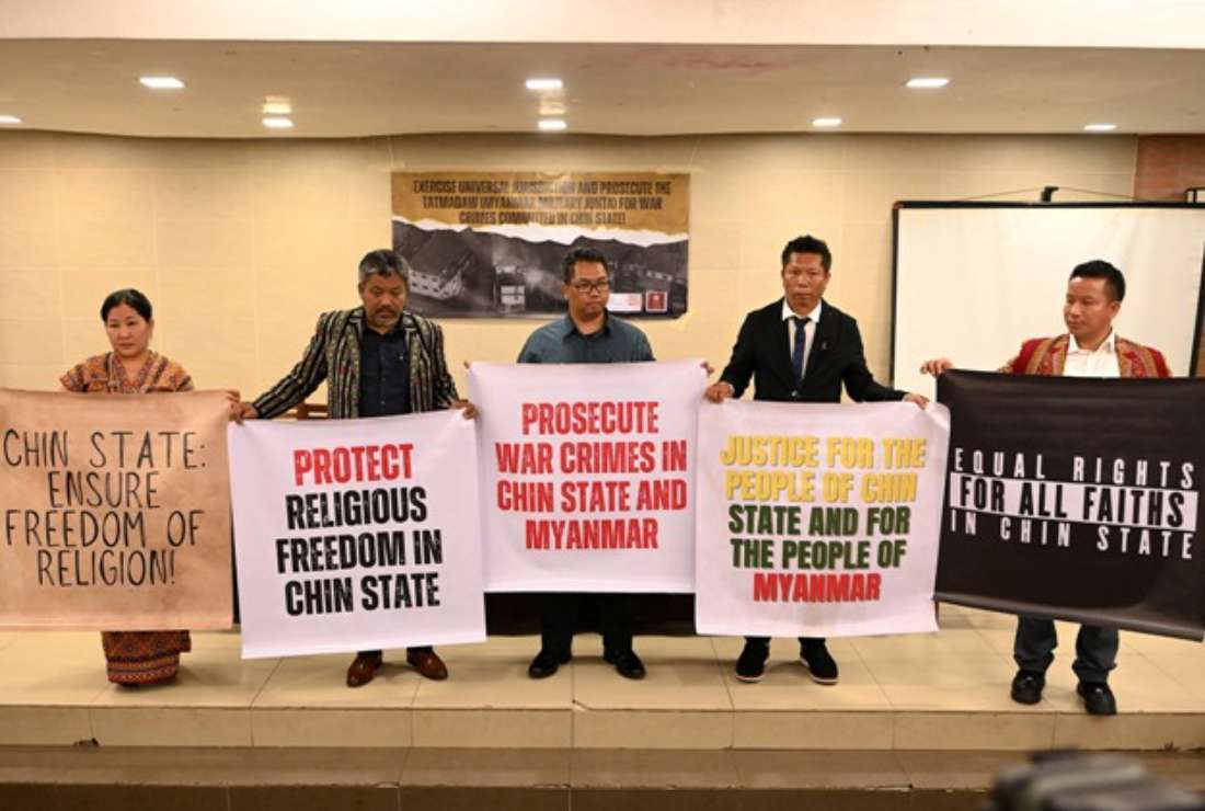 A group of Myanmar nationals raise banners during a press conference after filing a criminal complaint in Manila on Oct. 25 urging the Philippines to investigate alleged war crimes committed by 10 serving or former members of Myanmar's military against the mainly Christian Chin minority.