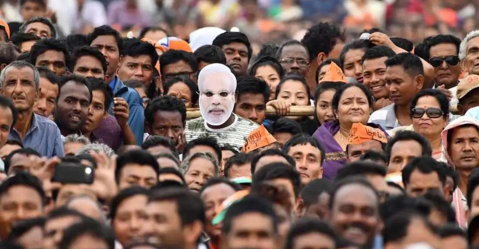 A supporter of India's pro-Hindu Bharatiya Janata Party wears a mask of Prime Minister Narendra Modi at a political rally in northeast Assam state on March 30, 2019. Christian leaders say threats to Church-run institutions in the state are growing with Hindu groups pushing their brand of cultural nationalism.